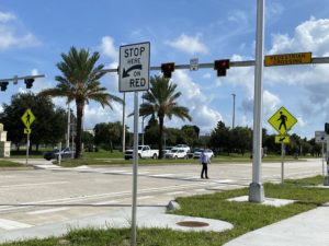 Pedestrian crossing the street at a pedestrian hybrid beacon